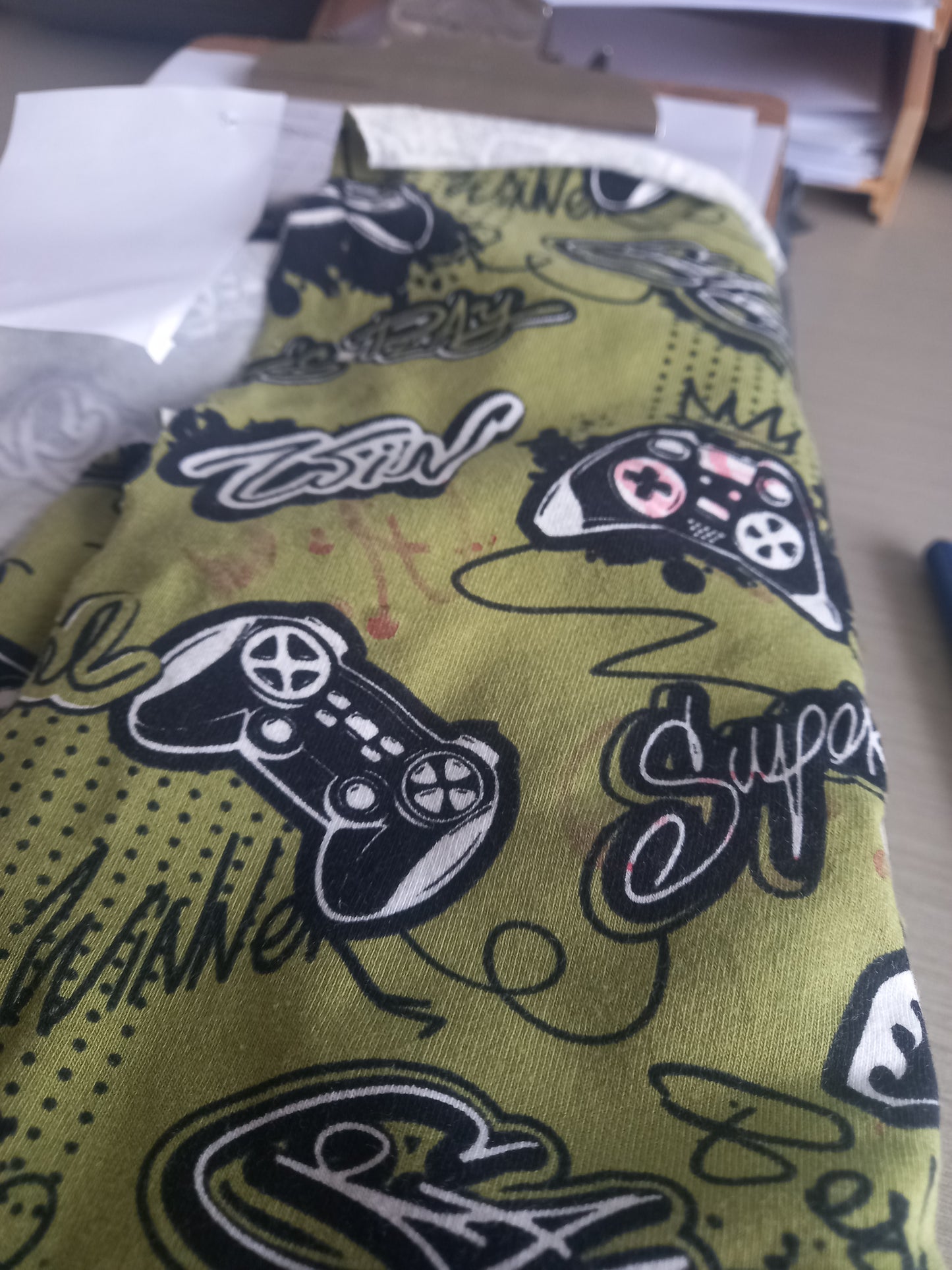 Video games on Olive - Cotton Spandex - 1 metre remnant - print mark on fabric