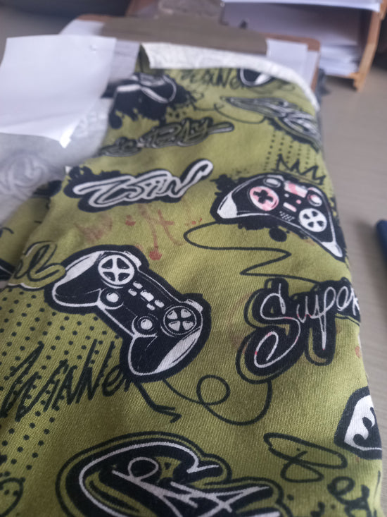 Video games on Olive - Cotton Spandex - 1 metre remnant - print mark on fabric